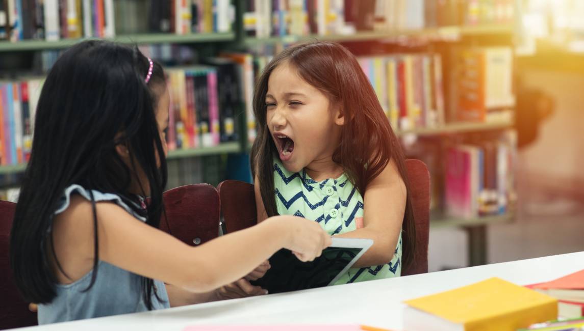 dwie dziewczynki kłócą się w szkole
