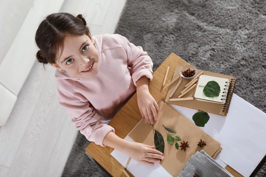 Little,Girl,Working,With,Natural,Materials,At,Table,Indoors,,Top